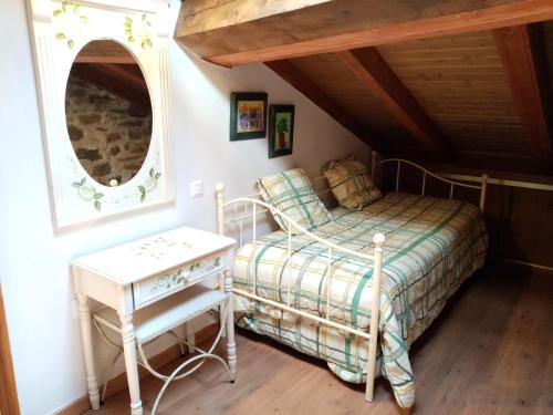 a bedroom with a bed and a table and mirror at La torna in Navarredonda de Gredos