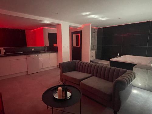 un salon avec un canapé et une table dans l'établissement Love Room avec Baignoire Balnéo Jacuzzi, à Saint-Étienne