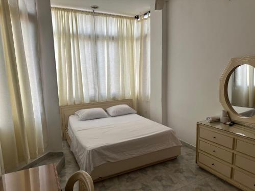 a bedroom with a bed and a mirror and a dresser at Hotel Sandiego in Puerto Berrío