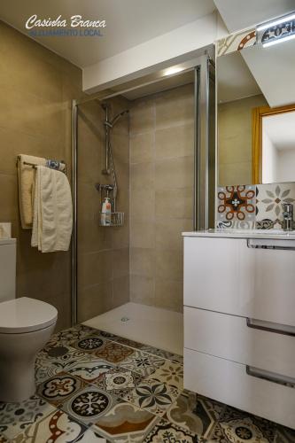 a bathroom with a shower and a toilet at Casinha Branca in Fundão