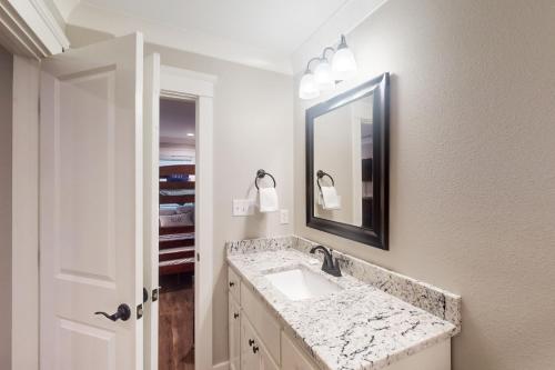 a bathroom with a sink and a mirror at Beach Cottage South in Dauphin Island