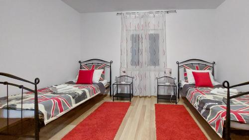 1 dormitorio con 2 camas y alfombra roja en Mediterranean Apartment Mendy, en Kaštela