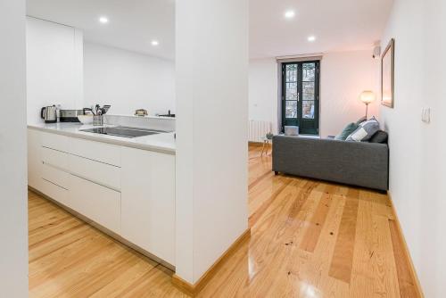 a kitchen with a sink and a couch in a room at GuestReady - Green Bay Garden in Porto