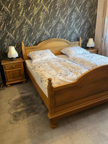 a wooden bed with two night stands and two lamps at FeWo Anastasija 