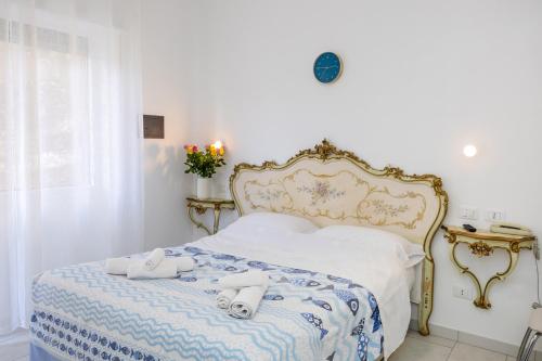 una camera da letto con un letto e due asciugamani di B&B Oasi a Finale Ligure