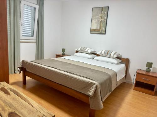 a bedroom with a bed with pillows on it at Apartments Cvitanović Korčula in Korčula