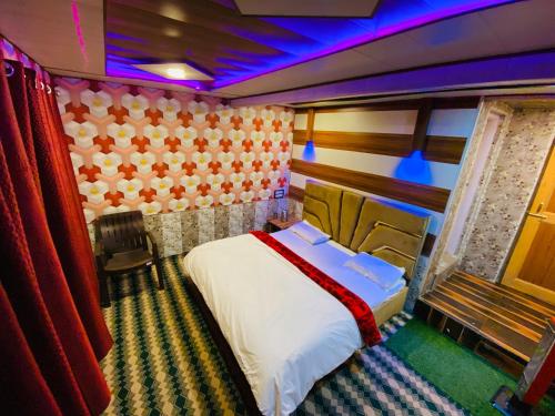 The GRITTI CASTLE HOTEL AND RESTAURANT في Kanzalwan: غرفة نوم مع سرير في غرفة مع أضواء أرجوانية