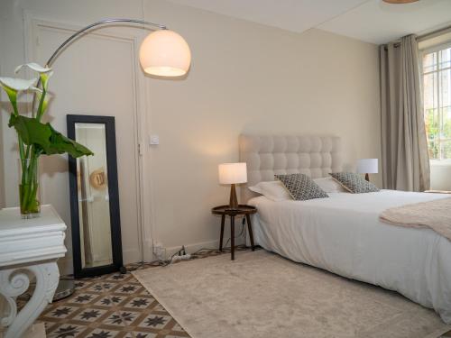 a bedroom with a white bed and a mirror at La chambre du soleil in Lézat-sur-Lèze