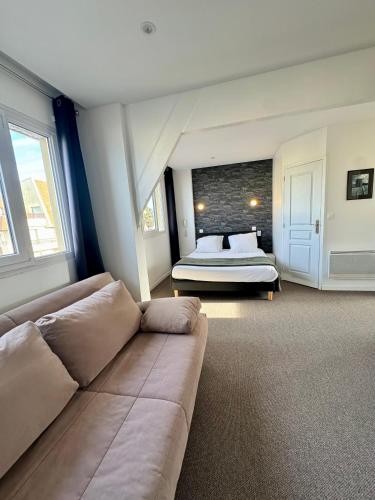 a living room with a couch and a bed at Le Clos Normand in Saint-Aubin-sur-Mer