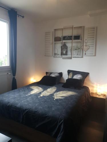 une chambre avec un grand lit avec deux oreillers dans l'établissement Maison cosy au calme avec jardin, à Agen