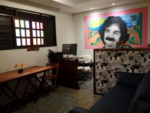 a room with a table and a painting of a man at Get Up Hostel in Natal