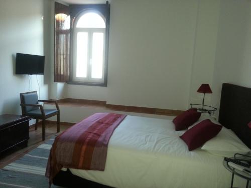 a bedroom with a large bed and a window at Casas da Moagem in São Domingos