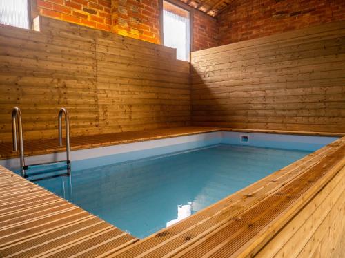 a swimming pool in a brick walled room with a swimming pool at Le RELAIS DE LEZAT in Lézat-sur-Lèze