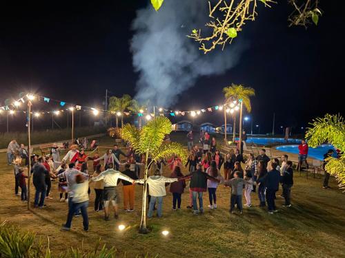 a crowd of people standing in a park at night at Vale Das Águas Fazenda Resort in Águas de Santa Barbara