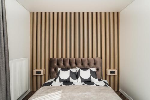 a bedroom with a bed with a brown headboard at Riverra House - Panorama View Apartment in Kaunas