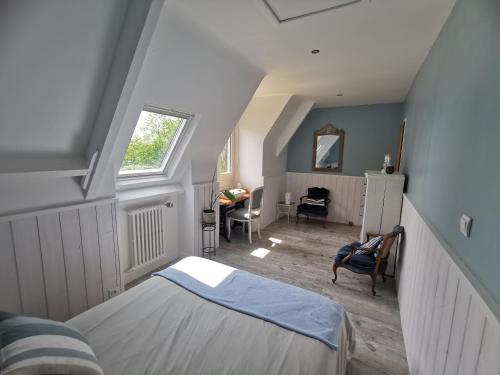 a attic room with a bed and a desk at Les pieds dans l'eau in Saint Malo