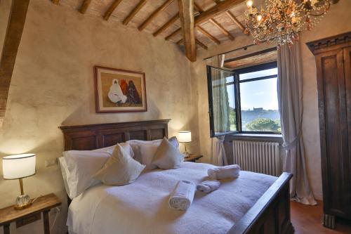 una camera da letto con un letto con lenzuola bianche e una finestra di Luxury Villa - Torre Collevento - Orvieto a Orvieto