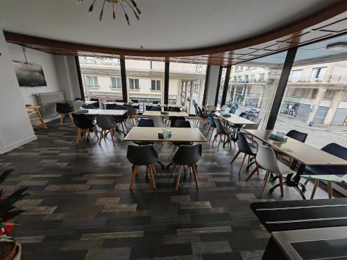 勒阿弗爾的住宿－勒阿弗爾中心宜必思尚品酒店，一间设有桌椅的餐厅,位于带窗户的房间内
