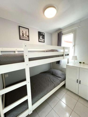 une chambre avec deux lits superposés et un bureau dans l'établissement BARCARESA-Villa cosy en bord de mer, idéalement située, au Barcarès