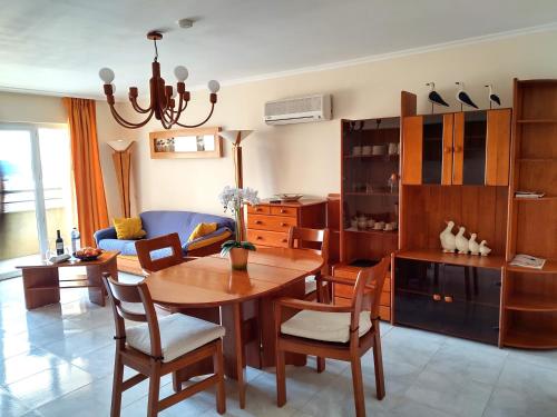 - un salon avec une table et des chaises en bois dans l'établissement DOM ELENA - JARDINS DA ROCHA, à Portimão