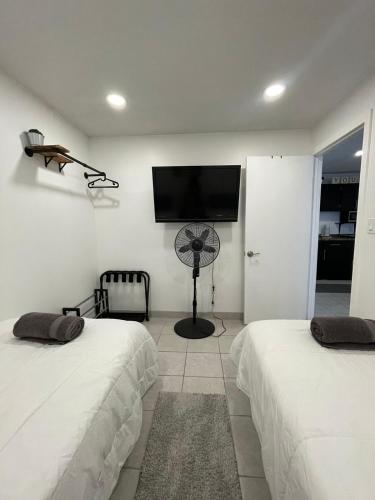 a bedroom with two beds and a flat screen tv at Villa Angel in Tijuana