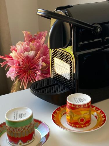 two cups sitting on plates next to a toaster at Luxury Villa with Pool & Sea View-10 Minutes from Monaco in Èze
