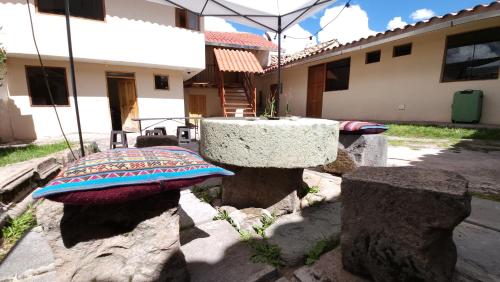een stenen tafel en wat rotsen en een gebouw bij Munay Cusco in Cuzco