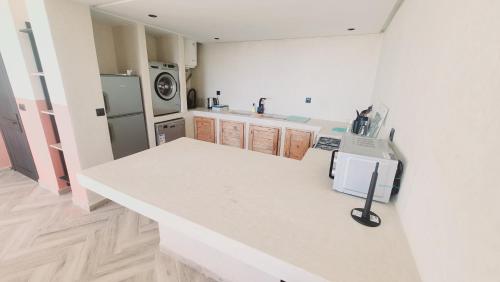 a kitchen with a white counter and a refrigerator at Appartement vue sur mer in Tangier