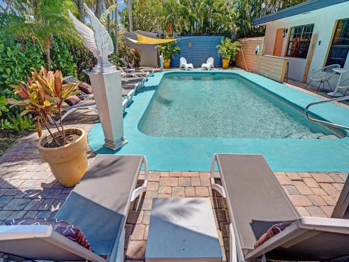 a swimming pool with two lounge chairs next to a house at Gay Clothing Opt Studio in heated pool guesthouse in Fort Lauderdale