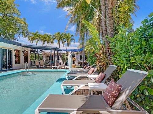 a resort pool with lounge chairs and palm trees at Gay Clothing Opt Studio in heated pool guesthouse in Fort Lauderdale