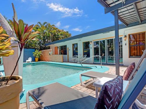 a swimming pool with lounge chairs and a house at Gay Clothing Opt Studio in heated pool guesthouse in Fort Lauderdale