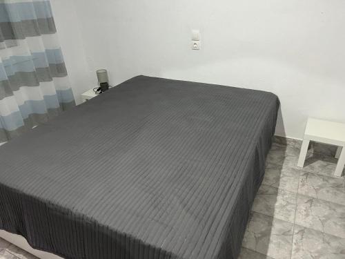 a bedroom with a bed with a gray bedspread at Cottage Karanikola in Sikia