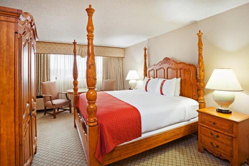 a bedroom with a large bed with a wooden frame at Holiday Inn Johnson City by IHG in Johnson City