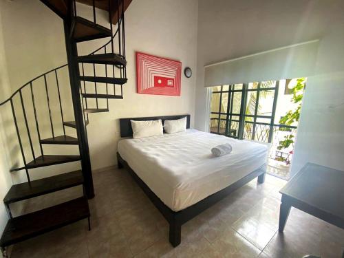 1 dormitorio con 1 cama y escalera de caracol en Hotel Maya Turquesa en Playa del Carmen