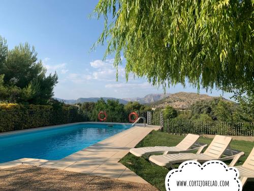 a villa with a swimming pool and two lounge chairs at Cabañas Cortijo el Helao in Pozo Alcón