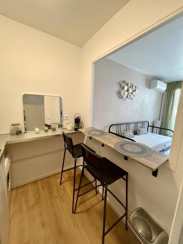 Cette petite chambre comprend une table, des chaises et un lit. dans l'établissement Joli studio niçois proche mer, à Nice