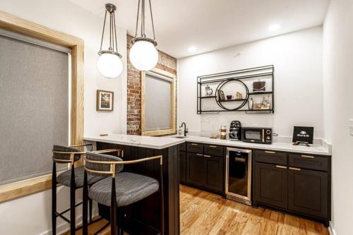 a kitchen with black cabinets and two bar stools at Historic DTWN Studio, Walk to Bathhouses, Shops, Room # 103 in Hot Springs