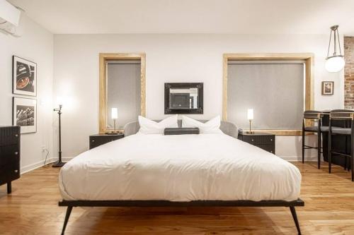 a bedroom with a large white bed and two windows at Historic DTWN Studio, Walk to Bathhouses, Shops, Room # 103 in Hot Springs