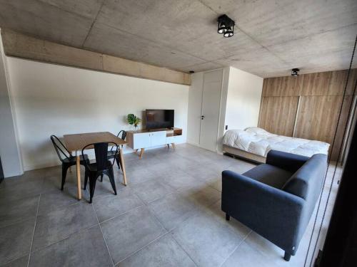 Una sala de estar con una mesa y una cama. en Monoambiente 2do piso de calidad en Pichincha, en Rosario