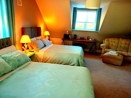 a bedroom with two beds and a couch and a window at White Quarry Hse Quarry Road in Navan