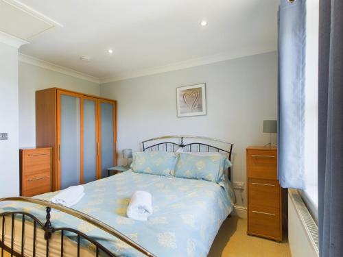 a bedroom with a bed with a blue comforter at 12A Solent Landing direct beach access in Bembridge