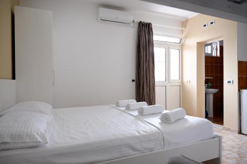 a white bed with two towels on top of it at Hotel 'DEL MAR' - Shengjin in Shëngjin