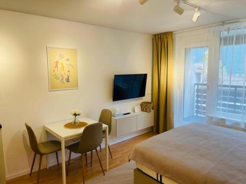 a bedroom with a bed and a table and a television at Cozy Apartment Bovec in Bovec