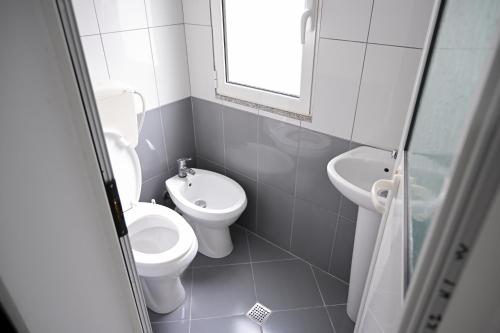 uma casa de banho branca com um WC e um lavatório em Hotel 'DEL MAR' - Shengjin em Shëngjin