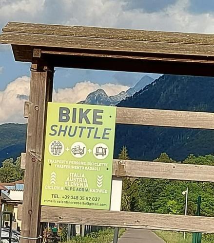 a yellow bike shuttle sign on a wooden fence at The only Traditional Resian Home in Giulie Alps in Stolvizza