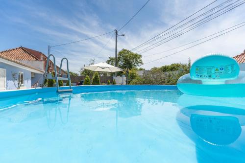 een groot zwembad met een blauw zwembad bij Moradia Familiar Piscina 5min Praia by HOST-POINT in Charneca