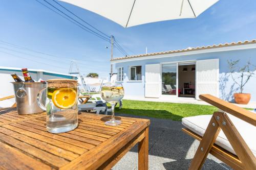 una mesa con dos copas de vino y una naranja en ella en Moradia Familiar Piscina 5min Praia by HOST-POINT, en Charneca