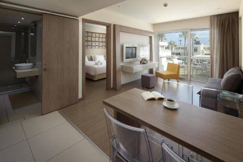 a living room with a couch and a table in a room at Melpo Antia Hotel & Suites in Ayia Napa