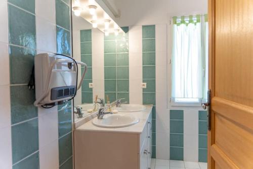 ein Badezimmer mit zwei Waschbecken und einem Spiegel in der Unterkunft Villa Tizzano Vue Mer in Sartène
