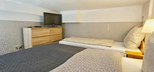 a hotel room with two beds and a flat screen tv at Holiday Home SLAVIA NEW 11 in Międzyzdroje